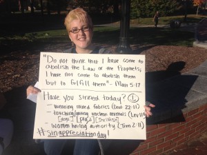 UConn student Riza Brown holds a sign to counter street preachers' proclamation of "Sin Awareness Day."