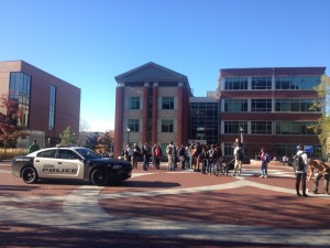 A police car drives past the crowd who has gathered around the street preachers who visited the UConn Storrs campus on Monday.