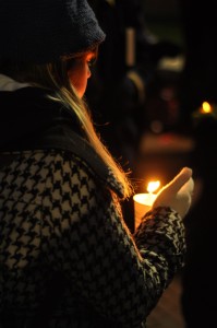 An attendee holds a candle during the vigil held at the University of Connecticut Storrs campus on Tuesday. (Photo by Santiago Pelaez)